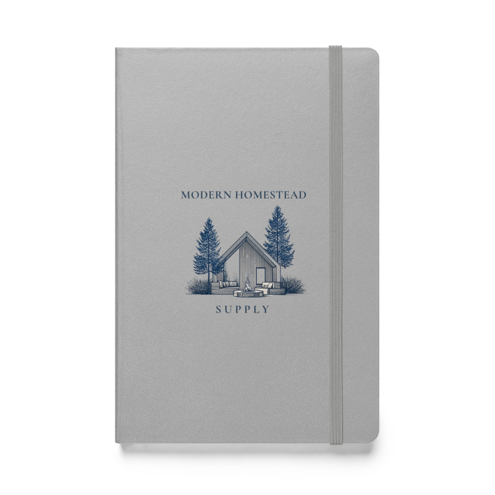Gray notebook with a cabin and tree illustration on the cover, labeled 'Modern Homestead Supply'.