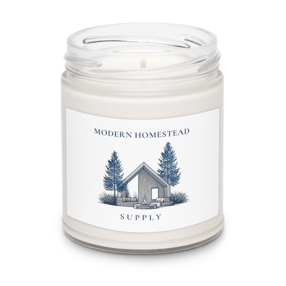 Candle in a jar with a label featuring a cabin and trees on a white background