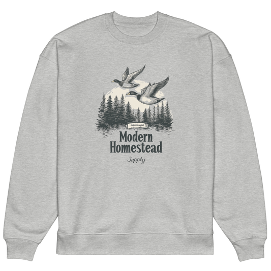 Gray sweatshirt with 'Modern Homestead Supply' graphic featuring ducks and trees on a white background