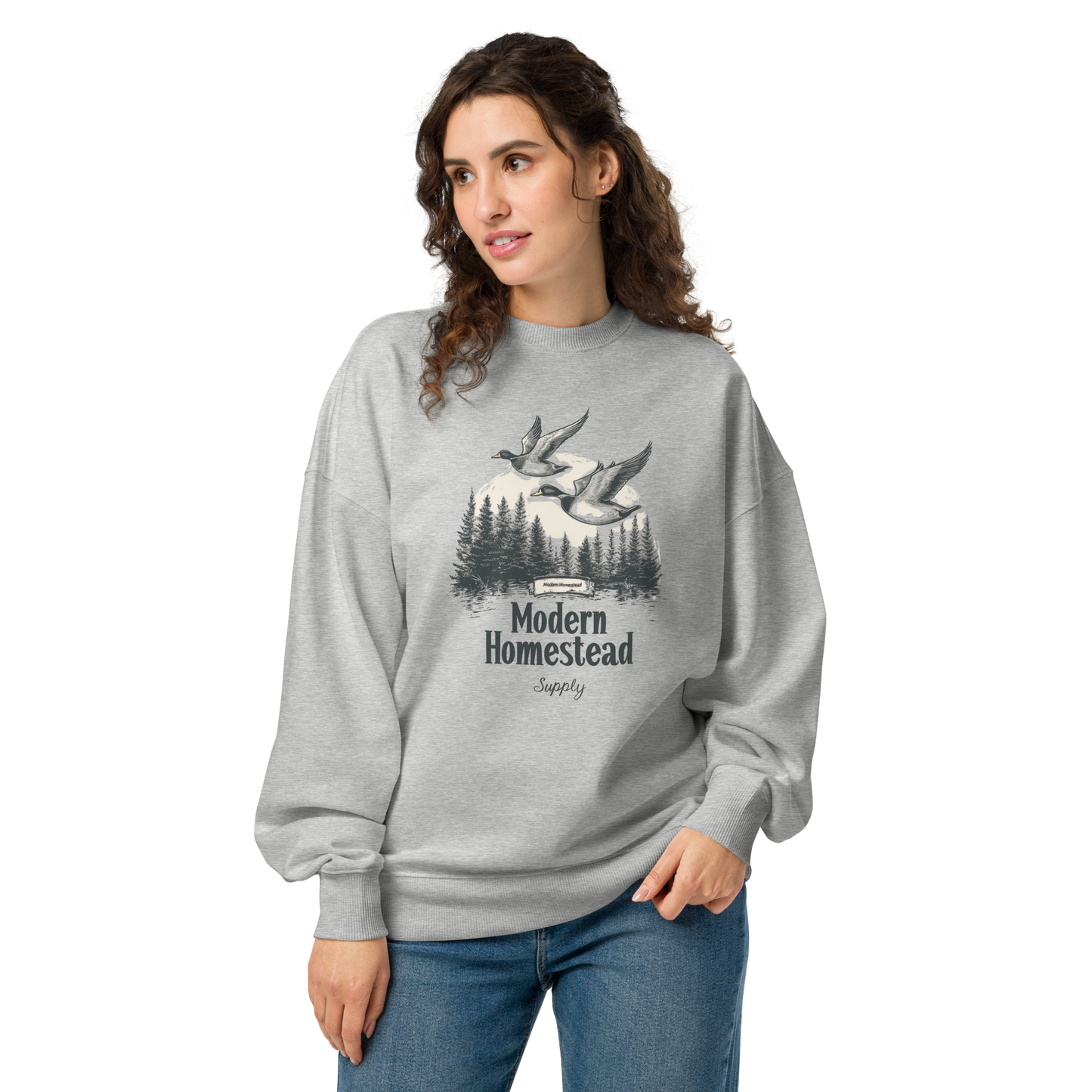 Woman wearing a gray sweatshirt with 'Modern Homestead Supply' design on a white background