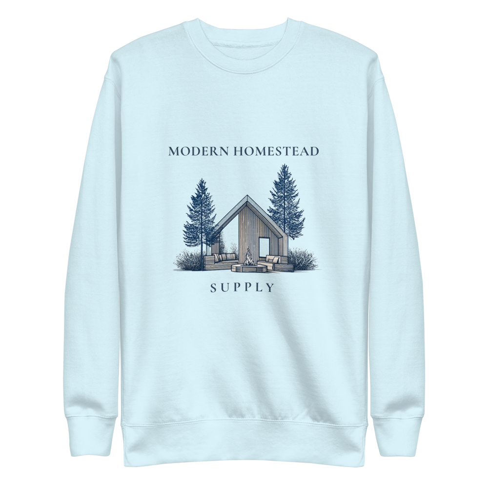 Light blue sweatshirt with a cabin and tree design on a white background