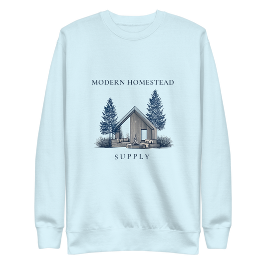 Light blue sweatshirt with a cabin and tree design on a white background