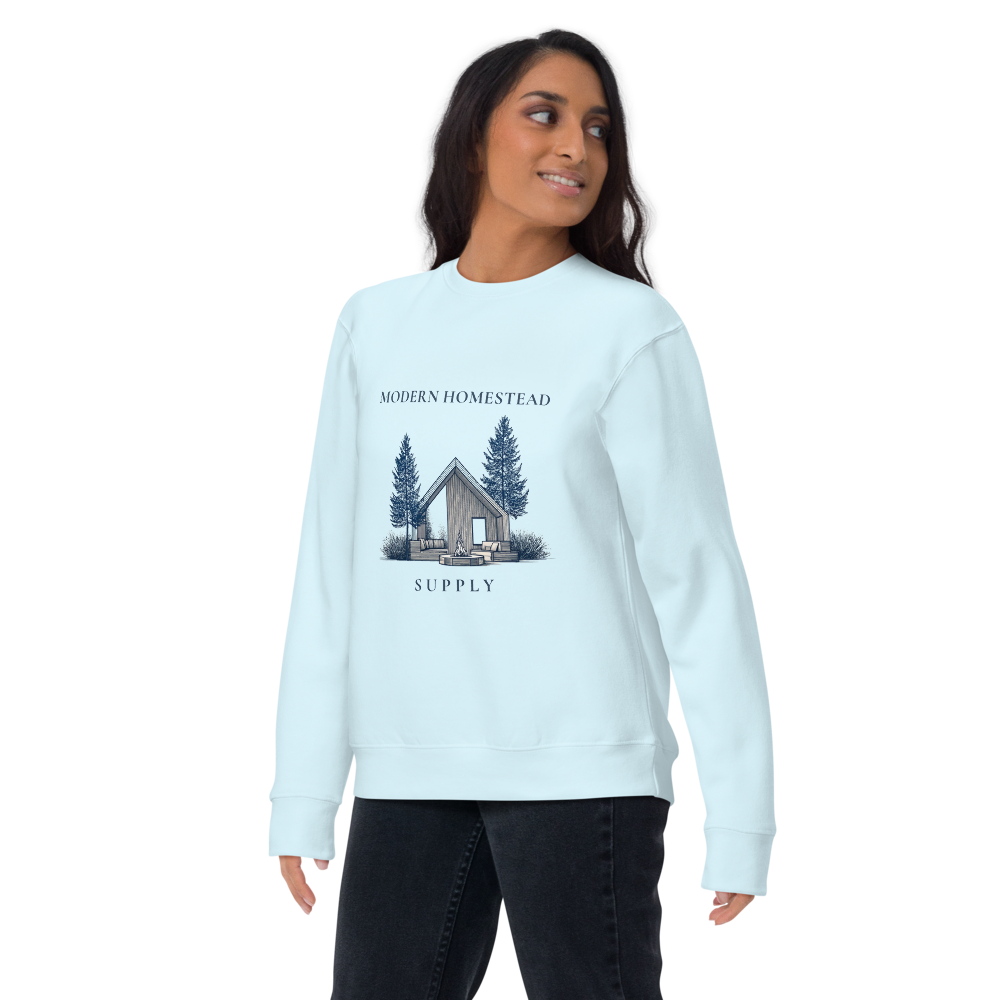 Woman wearing a light blue sweatshirt with a cabin graphic and text on a white background